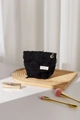 Detail of black textured fabric makeup bag with fringe tassels and flower zipper pull - Black Small