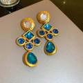 Vintage gold cross earrings with blue and clear gems on a matte grey background - Geometric Splicing Rhinestone Style (Silver Pin Rhinestone Circle Square Drop Earrings)