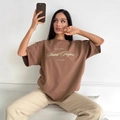 Übergroßes braunes Baumwoll-T-Shirt mit weißem Saint-Tropez-Grafikschriftzug-Design - S / Dunkelbraun