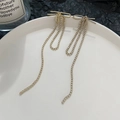 Elegant gold bow earrings with long tassels and white diamonds on ceramic tray - Gold Bowknot Rhinestone Tassel (5983)
