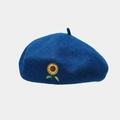 Macro detail of sunflower embroidery on navy blue wool beret showing fine needlework - One Size / Cyan Blue