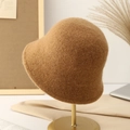 Knitted cloche bucket hat in brown wool blend displayed on a golden metal stand - Khaki