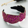 Detail eines lila Strass-Stirnbands mit floralem Kristallmuster auf schwarzem Samt - Rosarot