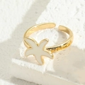 Verstellbarer goldener Seestern Ring mit weißer Emaille auf einem strukturierten Stein - Weiße Seestern (JZ0254)