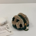 Dettaglio ravvicinato della custodia per auricolari in pile waffle con perla decorativa - Quadri Verdi