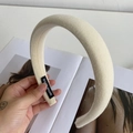 Beige padded fabric headband with handmade label shown in hand for texture detail - Milky White
