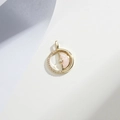 Macro shot of rotatable pink gold-plated pendant with crystals and centered gemstone - Gold Pink