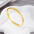 Bracelet jonc minimaliste en acier inoxydable doré sur un support décoratif blanc - Style à Charnière Sphérique / Doré