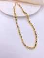 Detailed shot of gold necklace with multi-color cubic zirconia on white plate - Necklace