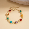 Dettaglio di una collana dorata con gemme ovali in resina colorata in stile vintage - Multicolore