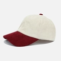 Detail of retro corduroy baseball cap showing cream crown and burgundy brim texture - Burgundy