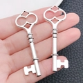 Macro detail of two heart-shaped antique silver key pendants on black leather - Peach Heart Shape Key (8465)