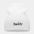 Detail van de witte gebreide muts met zwart Daddy borduursel op de omgeslagen rand - Daddy Borduurwerk / Wit