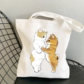 Cute canvas tote bag featuring a cartoon illustration of a cat and dog hugging - Cat and Dog Hugging