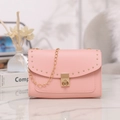 Pink leather crossbody bag with gold rivets and elegant chain strap details - Pink