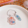 Pink acrylic bear keychain with orange party hat and lucky charm tag accessory - Good Luck Bear
