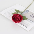 Single deep red velvet artificial rose placed on an open magazine for home decor - Small Velvet Rose Red