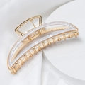 Detail view of crescent metal hair claw clip with white acetate texture on silk - Beige