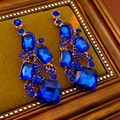 Dettaglio di orecchini vintage dorati con gemme blu sfaccettate e strass brillanti - Blu Profondo (Perno in Argento S925)
