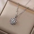Macro shot of silver clover pendant necklace with sparkling cubic zirconia on jewelry box - Clover Necklace / Silver