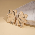 Dettaglio di orecchini dorati a forma di petalo con texture metallica a sbalzo - Oro