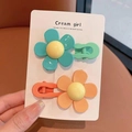 Primo piano di due dolci fermagli per capelli a fiore in verde e arancione vivace - Verde & Arancione (Set di 2)