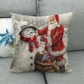 Housse de coussin Noël Père Noël et Bonhomme de neige sur canapé gris - Père Noël & Bonhomme de Neige Offrant des Cadeaux