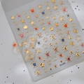 Macro detail of metallic gold star nail stickers with hollow and solid 3D colorful accents - Gold Stamping Multicolor Stars (CO-370)