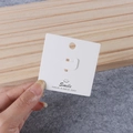 Close-up of white jewelry display card with Smile logo and hanging hole for accessories - Ring Card Style B 6*6cm (100 Pcs)