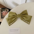 Elegant olive green satin bow hair claw clip with pearl edges on a white table - Green Pearl Double Bow Spring Clip
