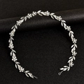 Silver bridal headband featuring crystal leaves and pearls on a textured black background - Silver