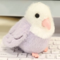 Plush purple parrot slap bracelet toy with white head sitting on a white keyboard - Charm / Purple