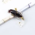 Miniature black resin koi fish figurine with gold flakes and clear fins on desk - Garnet