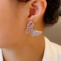Orecchini a farfalla con zirconi rosa e finitura argento indossati da una modella - Farfalla in Zircone Rosa
