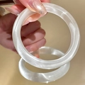 Close-up of translucent white cat eye stone bangle with silk luster on hand - Cat-eye Texture Style / White