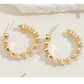 Close-up of gold C-shaped earrings with pear-cut zircon stones on a white stone base - White Heart Zirconia Style (ES2283) / Gold