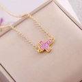 Minimalist gold necklace with a sparkling pink glitter cross pendant on a beige background - Pink