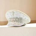 Dettaglio di cappello da sposa bianco con paillettes, perle, conchiglie e scritta BRIDE - Regolabile / Conca Bianca