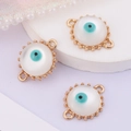 Macro shot of three golden evil eye connectors with white stones for jewelry DIY - Round Evil Eye (Double Link)