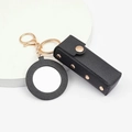 Detail of black leather lipstick pouch keychain with gold hardware and small mirror - Black