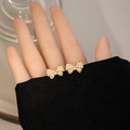 Elegant gold bow earrings with small pearls held by hand to show actual size - E2754-4 Gold Full Pearl Bow