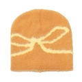 Detail of soft plush knit beanie with bow jacquard pattern in warm brown orange hue - M (56-58cm) / Yellow