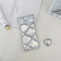 Detailed close-up of a silver quilted PU sunglasses pouch with a blue heart buckle - Diamond Grid Silver