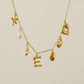 Detail view of 18k gold plated necklace with starfish, pearl and shell pendants - Letter E