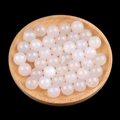 Polished white translucent agate half-hole beads displayed in a round wooden bowl - 12mm White Agate Semi Drilled Bead