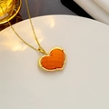 Elegante goldene Herzkette mit orangefarbenem Stein auf rundem Displayständer - Orangefarbenes Herz (326)