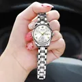 Detailed shot of silver quartz watch with white dial and day-date display held in hand - Silver Band White Dial - Women