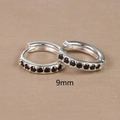 Macro shot of 9mm silver hoop earrings with round black zircon stones on wood surface - 9mm Silver Black Rhinestone (E1014-9mm)