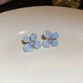 Macro shot of light blue crystal floral earrings with silver base on ceramic plate - 925 Sterling Silver Earring Post Silver Light Blue Four-Petal Flower Style