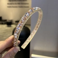 Close-up of sparkling pink and silver diamond rhinestones on a baroque metal headband - Champagne